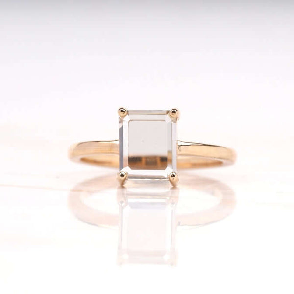 Radiant diamond ring with four-prong setting on a white background