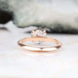 Romantic rose gold four prong solitaire ring displayed on couple’s hands