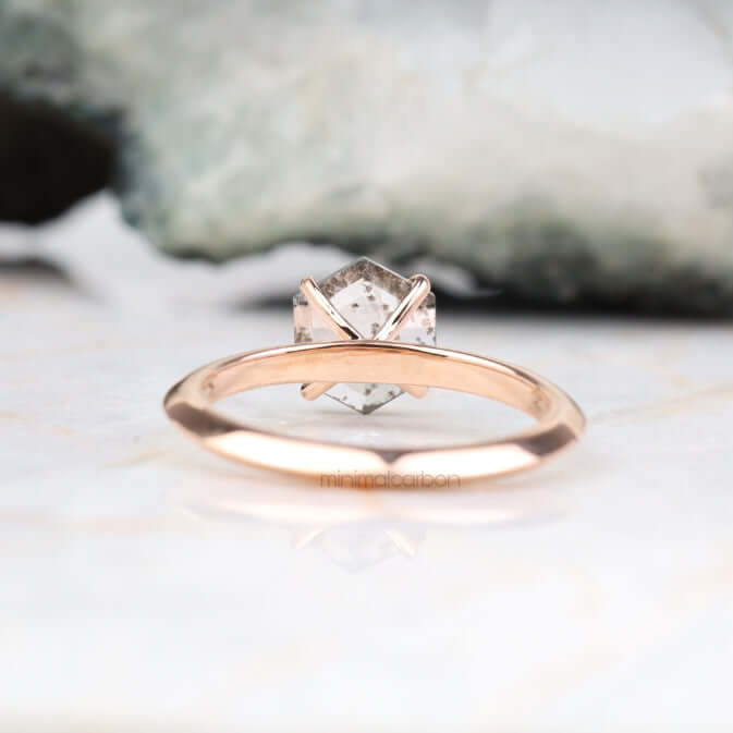 Romantic rose gold four prong solitaire ring displayed on couple’s hands