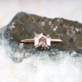 Four prong diamond ring showcased on a rustic background – moody and elegant shot