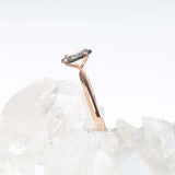 Rose gold engagement ring with four prong diamond displayed on a hand model