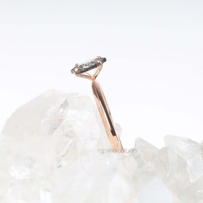 Rose gold engagement ring with four prong diamond displayed on a hand model