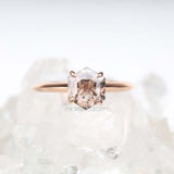 Hand holding rose gold four prong ring – intimate bridal jewelry display