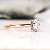 Diamond solitaire ring in white gold four prong setting floating on soft fabric