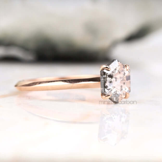 Diamond solitaire ring in white gold four prong setting floating on soft fabric