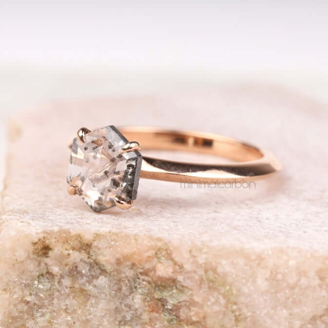 Side profile of rose gold four prong engagement ring worn on finger